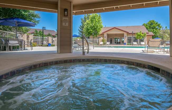 a spa with a pool and a house in the background