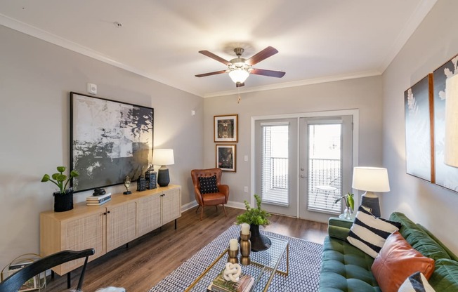 a living room with a ceiling fan and a large window