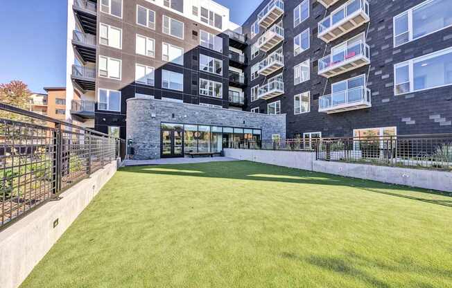 A large grassy area in front of a modern building.