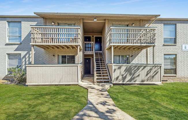 A two-story apartment building with a balcony on the second floor.