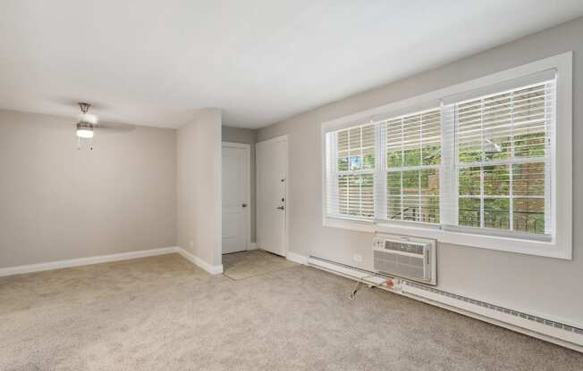 a bedroom with a large window and an air conditioner at The Hinsdale, Illinois, 60521