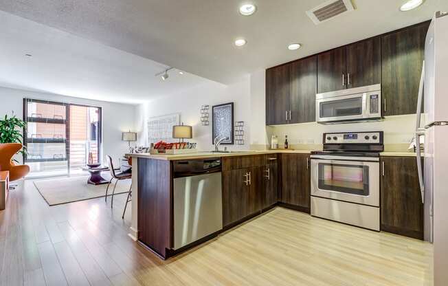 San Francisco CA Luxury Apartments - Venue - Sares-Regis - Gourmet Kitchen with Dark Wood-Style Cabinets and Stainless-Steel Appliances
