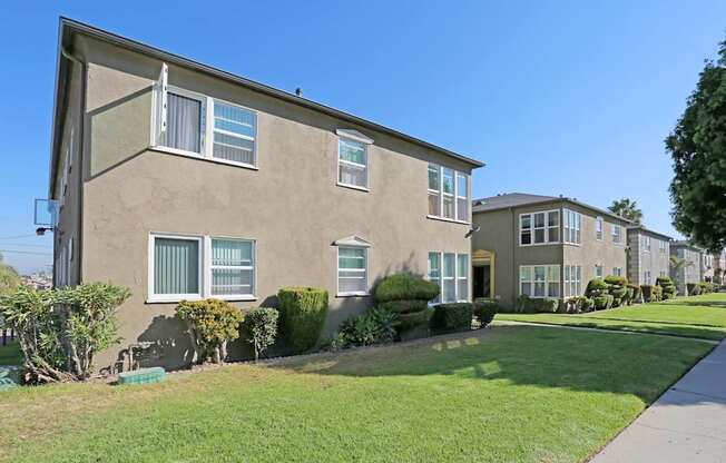 A row of houses with green lawns in front.