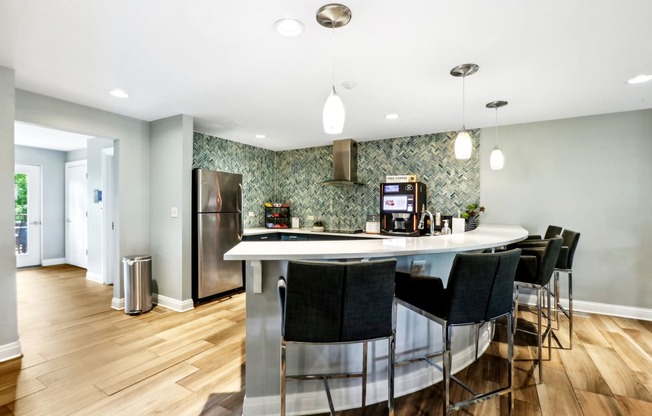 a kitchen with a bar and a stainless steel refrigerator