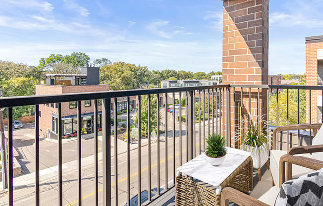 A balcony with a table and chairs overlooking a street.