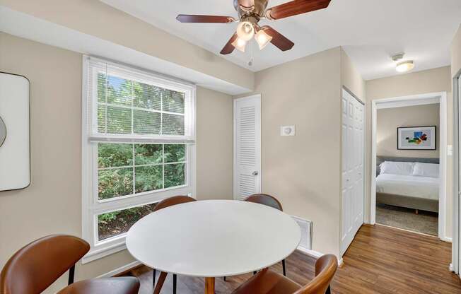 A room with a table and chairs and a window.