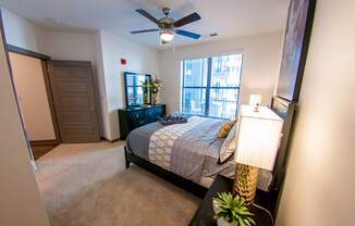 an empty bedroom with a bed and a ceiling fan