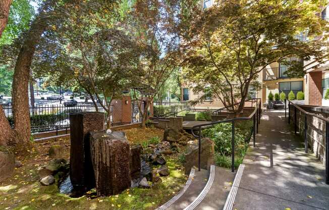 a park with a creek and trees in front of a building