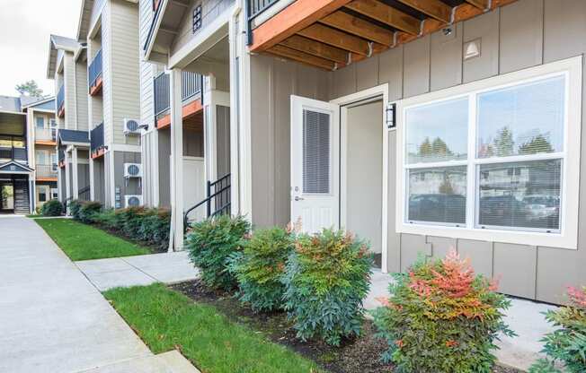 an exterior view of an apartment building with a sidewalk