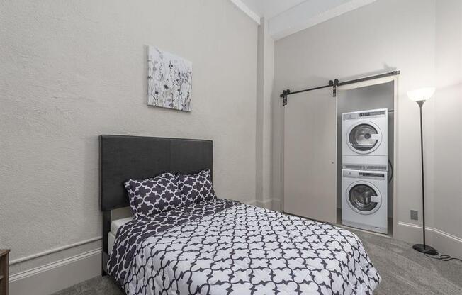 a bedroom with a bed and a washer and dryer