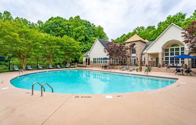 A large swimming pool in front of a clubhouse.