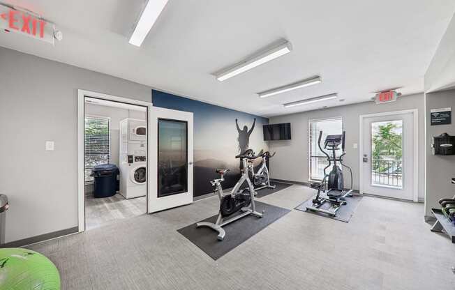 a gym with exercise equipment and windows in a building