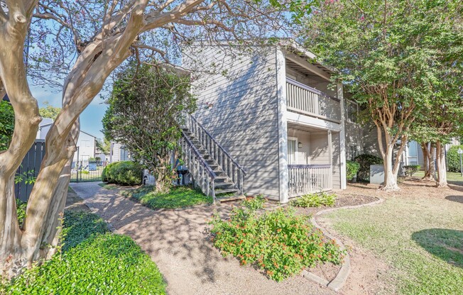 Two-story apartment building with beautiful landscaping surrounding it at Laurel Parc apartments in Shreveport, LA.
