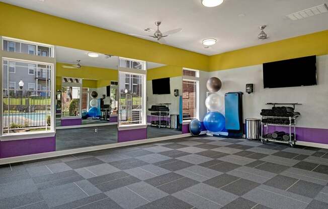 a fitness room with yellow walls and purple and yellow accents