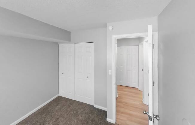 the living room of an apartment with white walls and wood floors