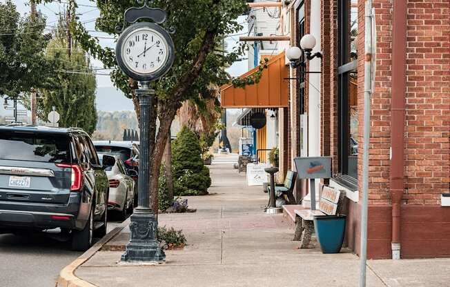 A street scene with a clock post in the foreground.