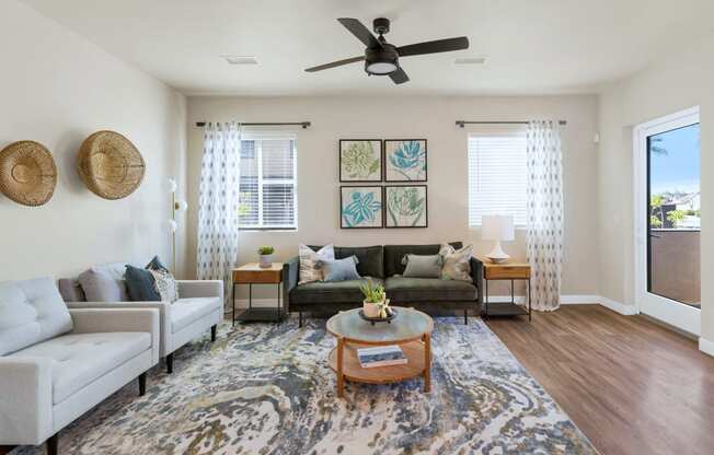 a living room with a ceiling fan and couchesat Solace at Ballpark Village, Goodyear, AZ