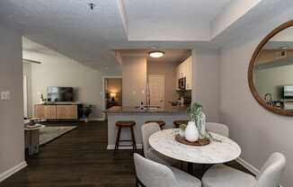 a living room and dining room with a table and chairs
