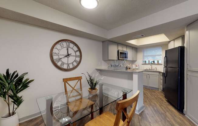 an open kitchen and dining room with a large clock on the wall