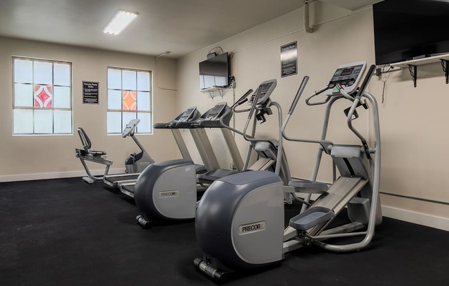 A gym with treadmills and elliptical machines.