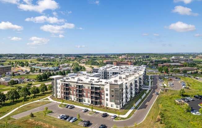 A large apartment complex with a parking lot in front.