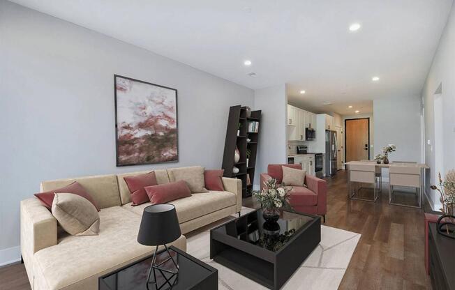 A living room with a beige couch, a black coffee table, and a painting on the wall.