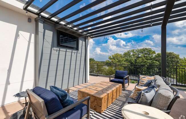 a patio with a pergola and furniture on it