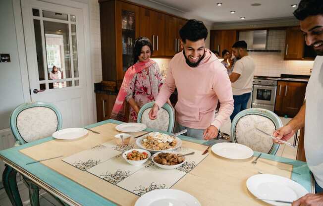A group of people are gathered around a table with plates of food.