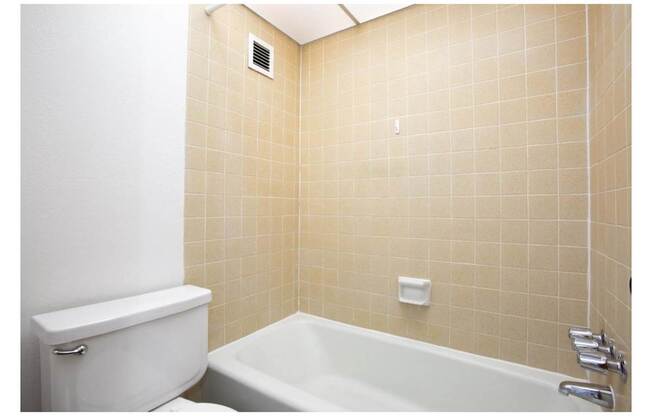 A white toilet next to a bathtub in a bathroom.