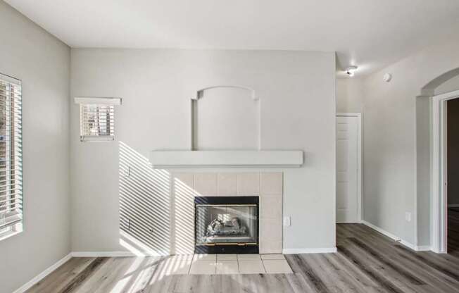 A modern living room with a fireplace and wood flooring.