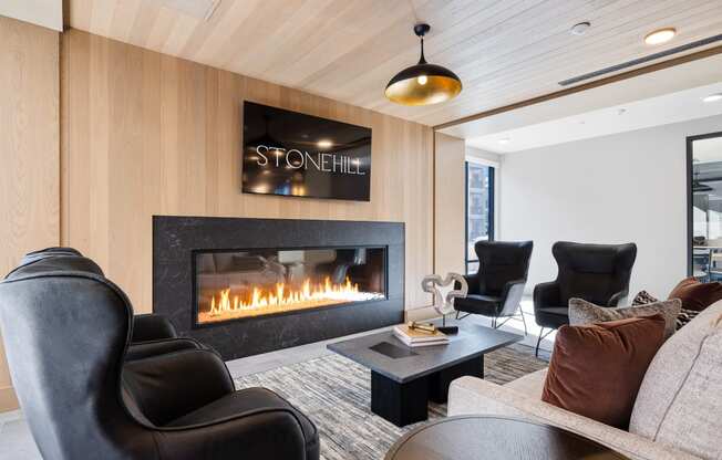 a living room with leather chairs and a fireplace