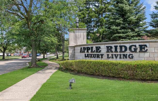 a stone sign with the words apple ridge luxury living in front of it