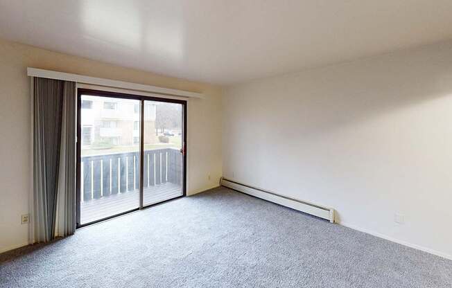 A living room with carpeting and a sliding glass door at Glen Oaks Apartments, Michigan, 49442