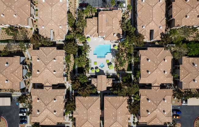 a birdseye view of a group of houses with a pool in the middle