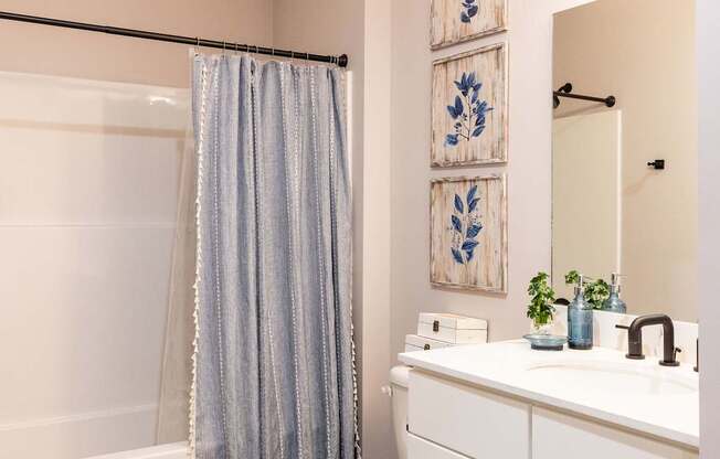 A bathroom with a toilet, sink, and shower.