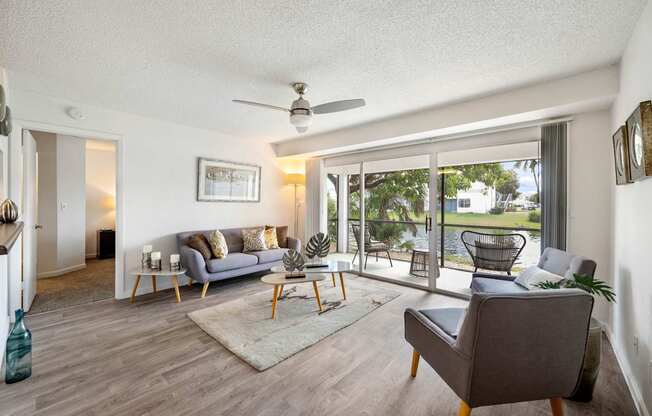 a living room with couches and chairs and sliding glass doors to a patio