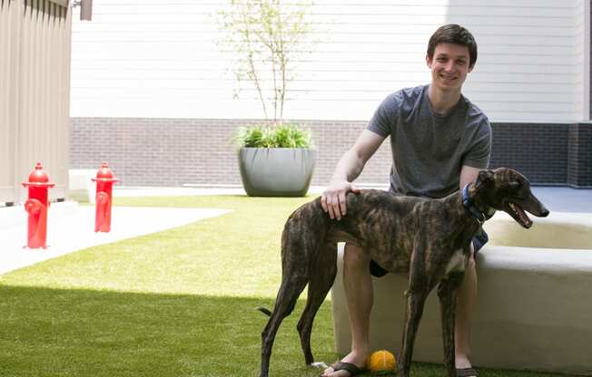 a man sitting on a couch with his dog