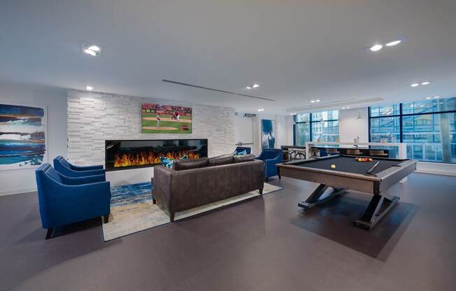 A room with a pool table and a fireplace.
