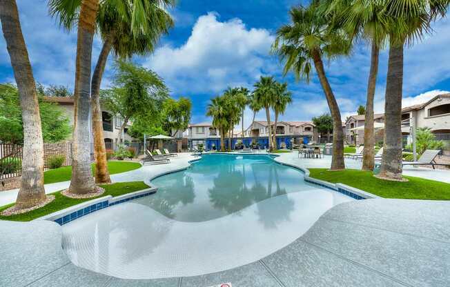 A swimming pool surrounded by palm trees and a no swimming sign.