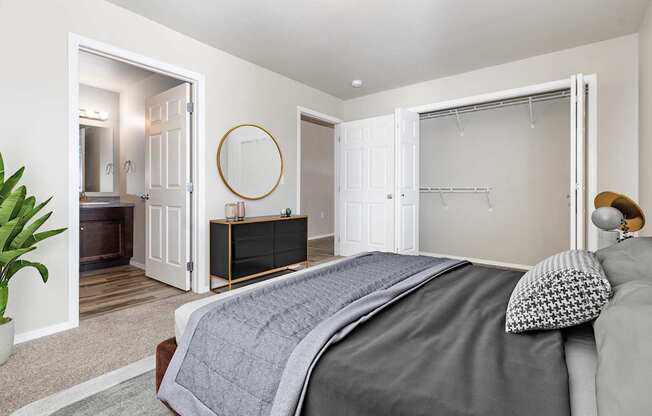 A bedroom with a large bed and a dresser with a mirror.