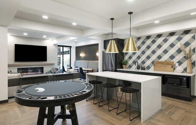 a kitchen with a round game table and a bar with stools