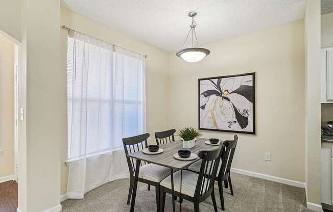 A dining room with a table set for four.