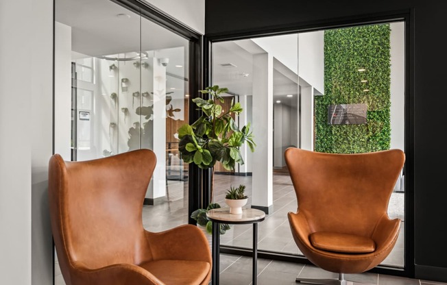 a living room with two brown chairs and a green wall