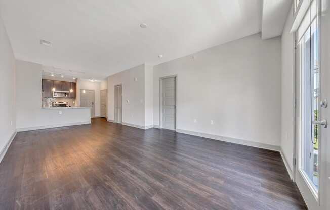 the living room and kitchen of an apartment with wood flooring