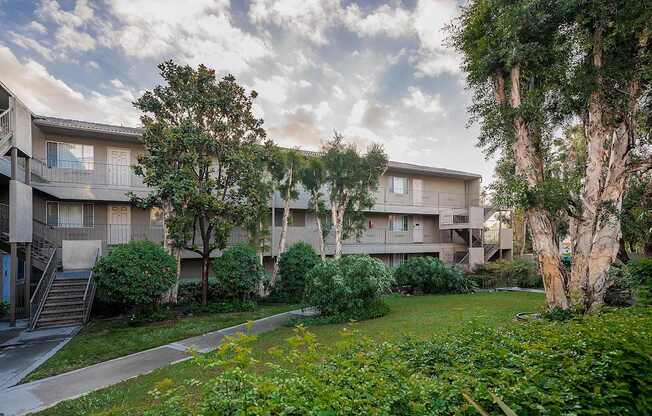 Apartment complex with greenery in front.