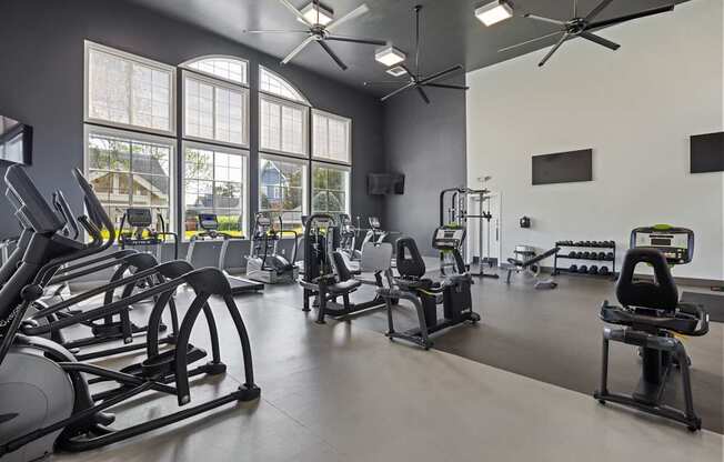 A gym with a variety of equipment including treadmills, stationary bikes, and weight machines.