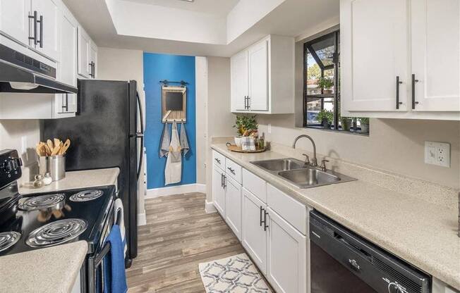 a kitchen with a sink and a stove and a refrigerator