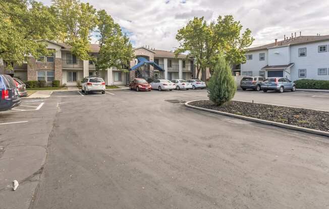 a parking lot with cars in front of apartment buildings