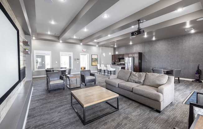 A modern living room with grey carpeting and furniture.
