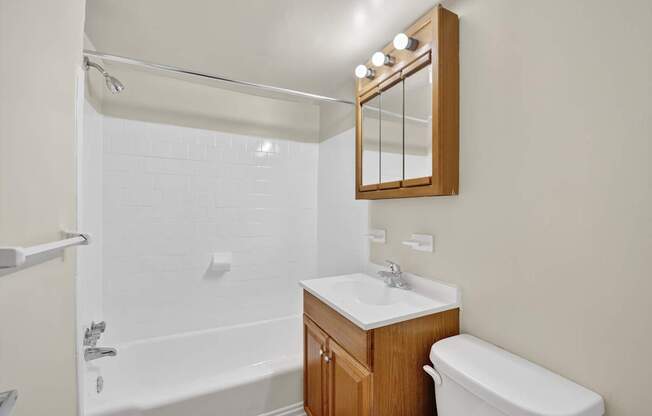 A white bathroom with a sink, toilet and bathtub.